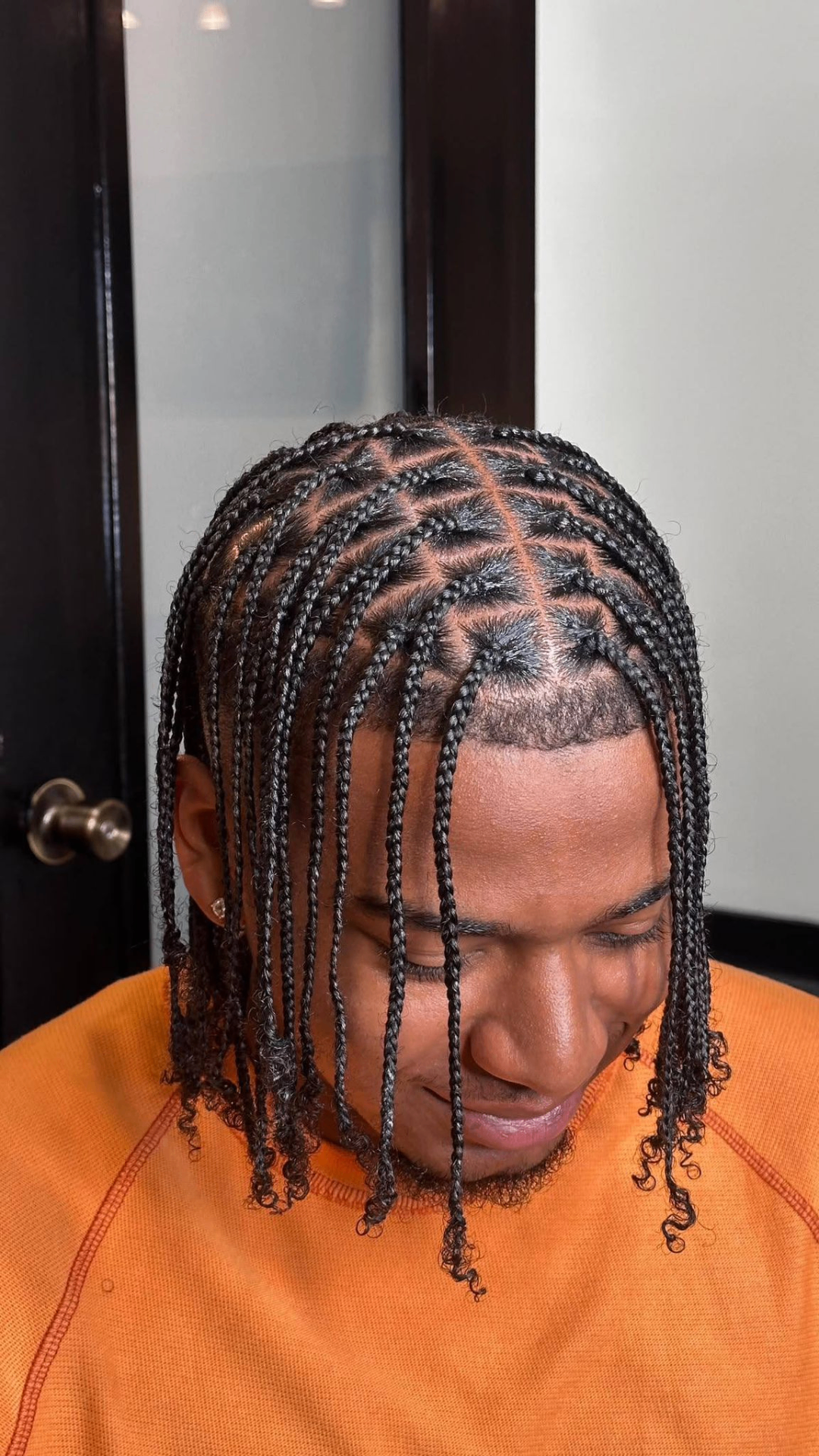Men’s braided style with small braids and clean parting